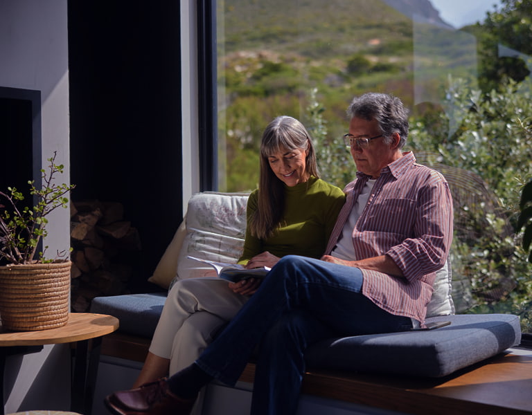 Wealth management image of happy couple reading a book